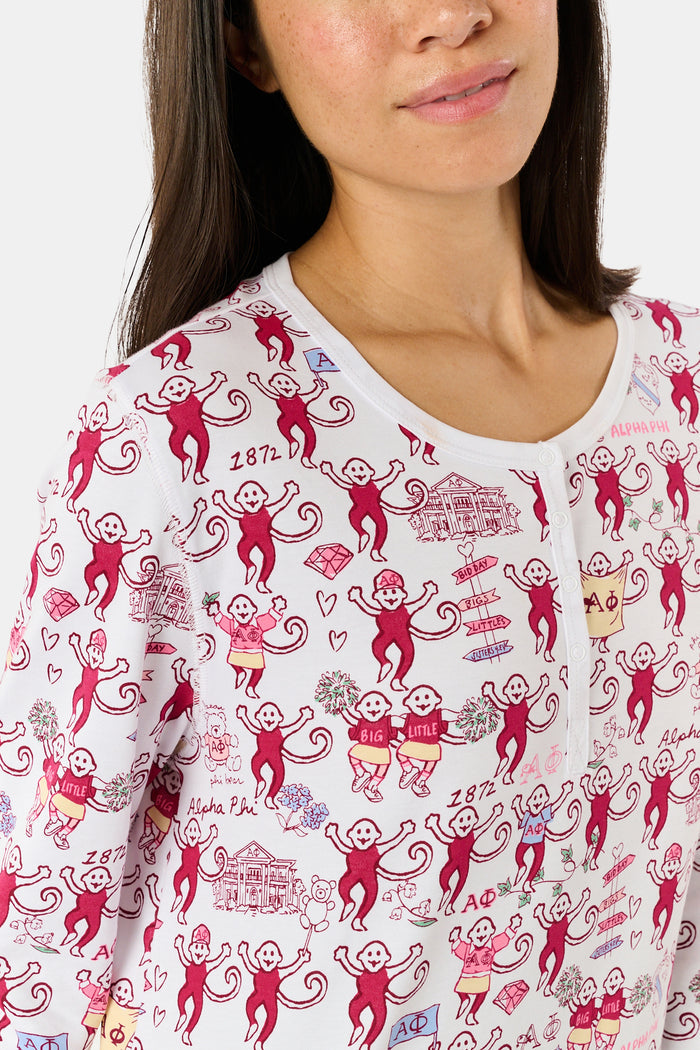 The Alpha Phi Monkey Pajamas by Roller Rabbit are a long-sleeve pajama set crafted from soft Pima cotton, featuring a red and gray cartoon animal print on a white background, with a Henley top and matching pants.