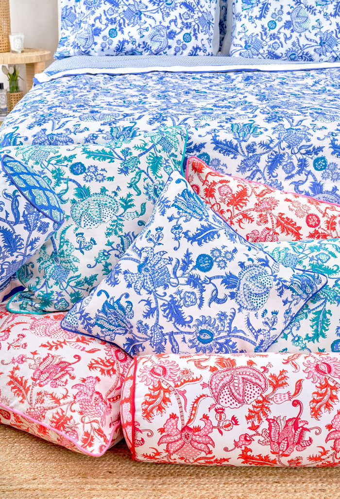 The Amanda Decorative Pillow by Roller Rabbit features an intricate blue and teal floral and bird hand-blocked print on white 100 cotton, finished with blue piping along the edges.