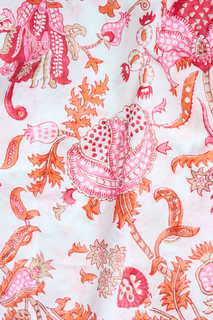 A woman poses against a plain background in the Roller Rabbit Amanda Lulu Set—cotton, short-sleeve, button-up pajamas with matching shorts in a pink and orange floral print.