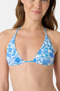 A woman models the Roller Rabbit Amanda/Jemina Serena Bikini Top in blue and white floral print, smiling gently. Her upper torso and lower face are shown against a plain backdrop.
