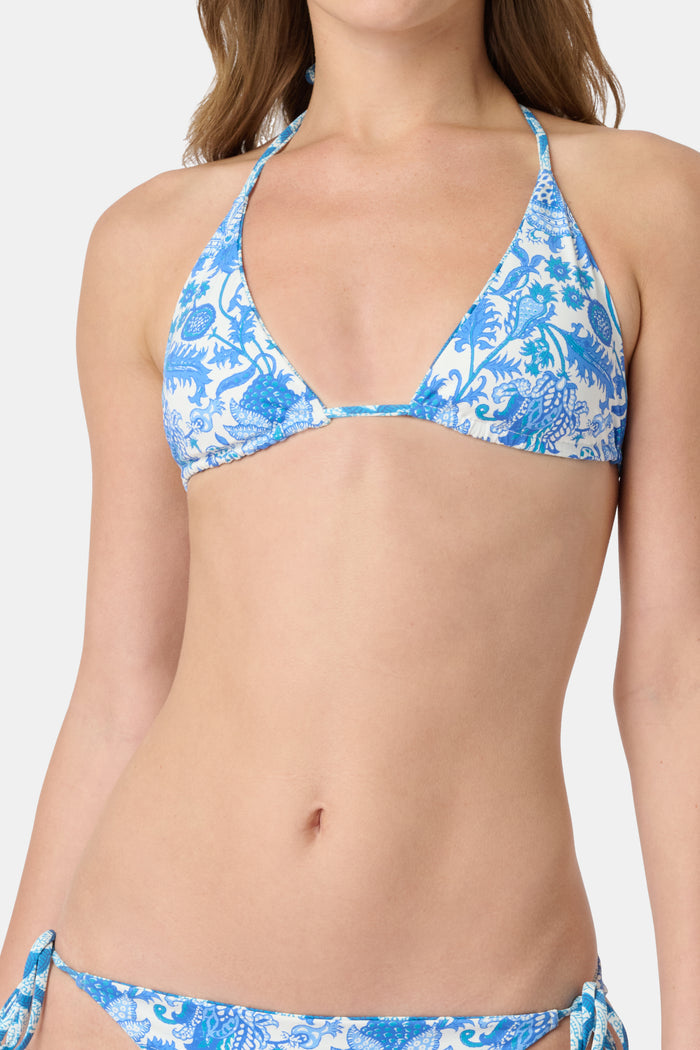 A woman models the Roller Rabbit Amanda/Jemina Serena Bikini Top in blue and white floral print, smiling gently. Her upper torso and lower face are shown against a plain backdrop.