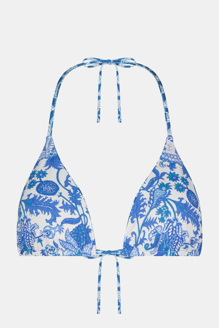 A woman models the Roller Rabbit Amanda/Jemina Serena Bikini Top in blue and white floral print, smiling gently. Her upper torso and lower face are shown against a plain backdrop.