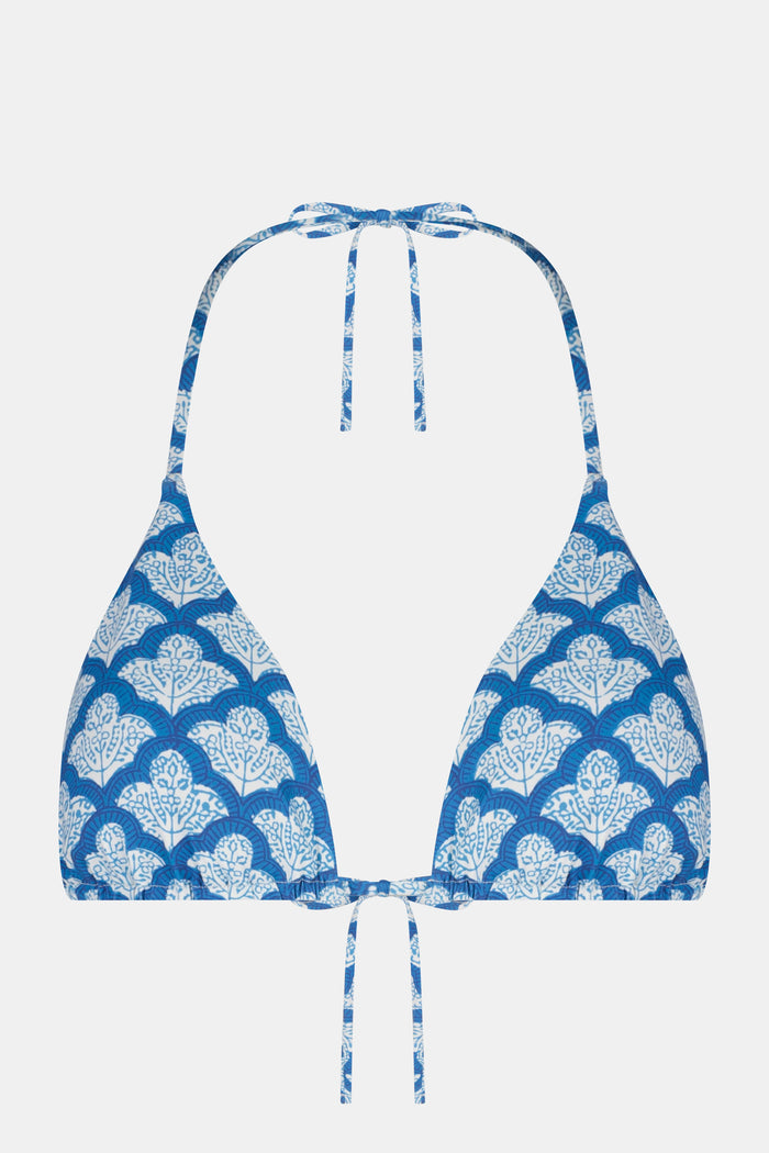 A woman models the Roller Rabbit Amanda/Jemina Serena Bikini Top in blue and white floral print, smiling gently. Her upper torso and lower face are shown against a plain backdrop.