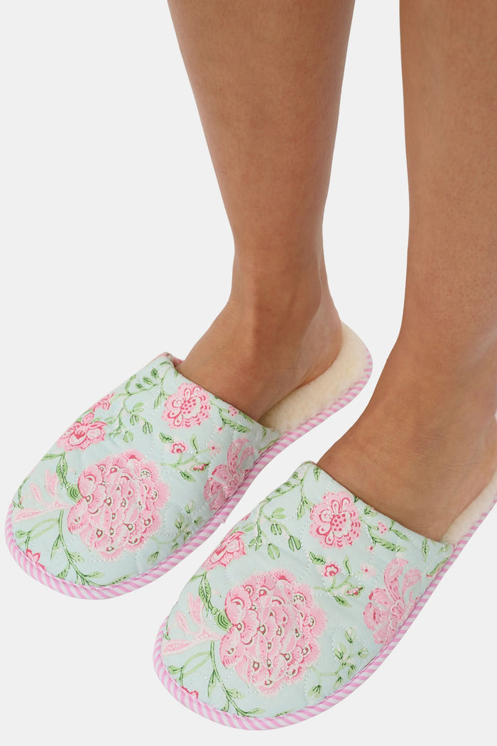 The Roller Rabbit Camellia Block Quilted Slippers are cozy, backless cotton slippers featuring a pink and green floral pattern on a light background, pink and white striped trim, and a soft cream-colored lining.