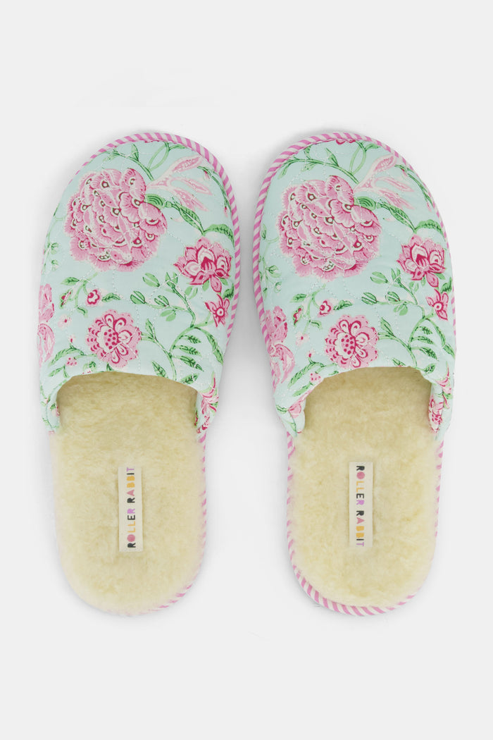 The Roller Rabbit Camellia Block Quilted Slippers are cozy, backless cotton slippers featuring a pink and green floral pattern on a light background, pink and white striped trim, and a soft cream-colored lining.