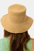 A person with long brown hair is seen from behind wearing the Hat Attack Chic Crochet Bucket Hat and a green top with white patterns against a plain background.