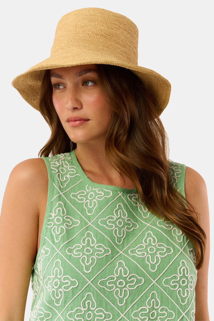 A person with long brown hair is seen from behind wearing the Hat Attack Chic Crochet Bucket Hat and a green top with white patterns against a plain background.