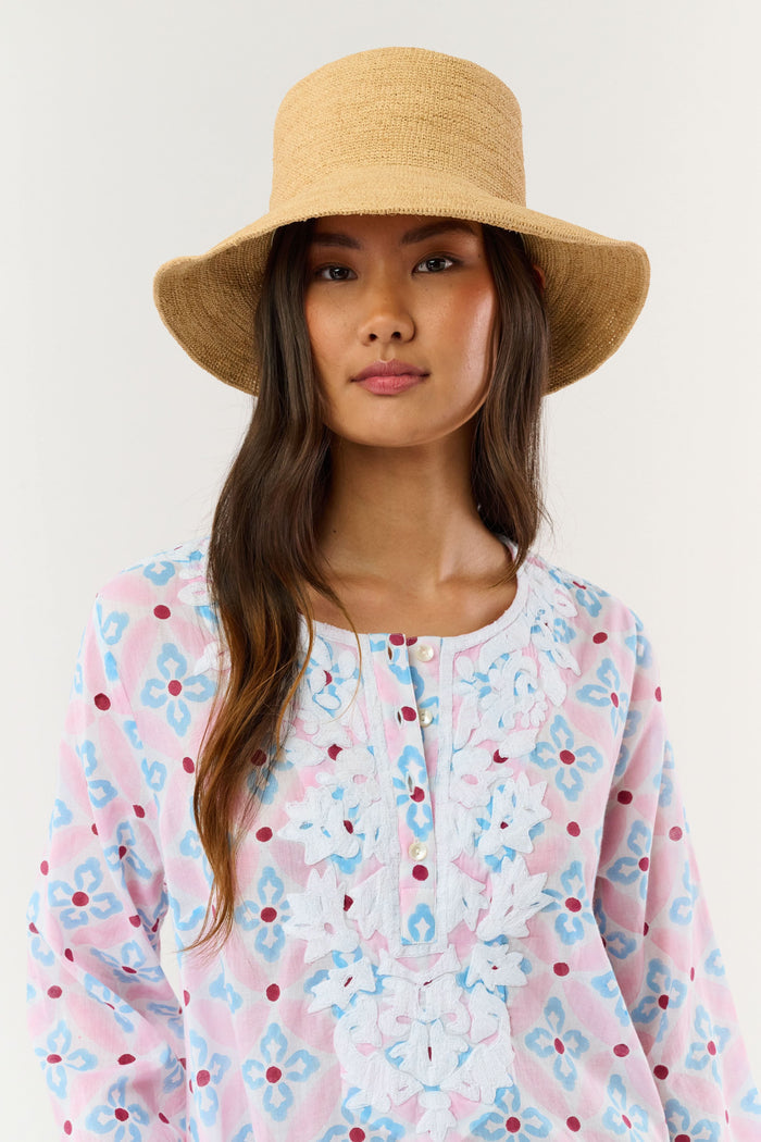 A person with long brown hair is seen from behind wearing the Hat Attack Chic Crochet Bucket Hat and a green top with white patterns against a plain background.