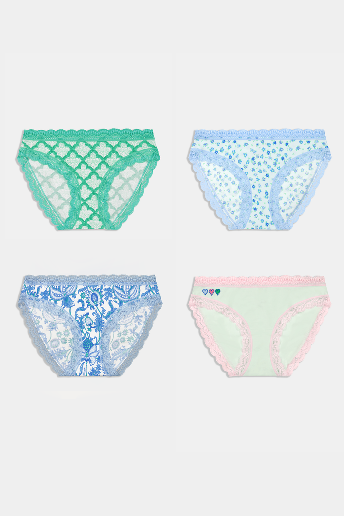 The Classic Core Bikini 4 Pack by Roller Rabbit includes four soft cotton modal panties, each with lace trim: green with hearts, light blue floral, white with blue paisley, and mint green with pink trim and embroidered hearts.