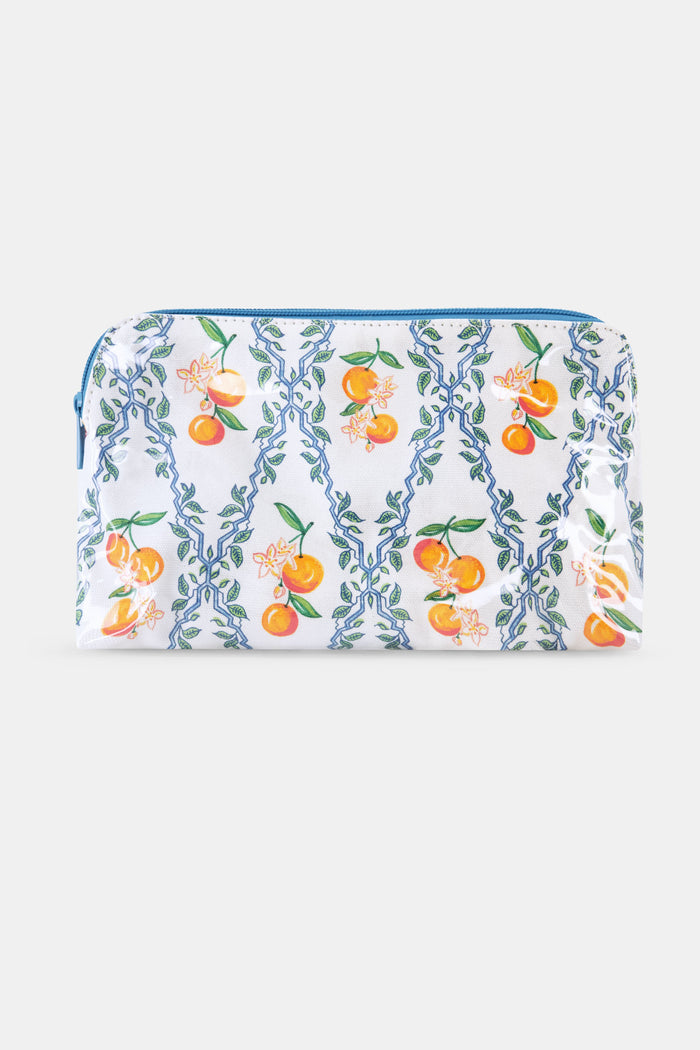 The Clementine Trellis Makeup Bag by Roller Rabbit is a zippered, water-resistant cotton canvas bag with a blue zipper and a white background featuring blue geometric lines, green leaves, orange fruits, and white flowers.