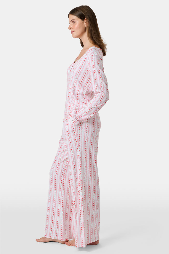 The Daisy Heart Stripe Boden Pant by Roller Rabbit features a wide-leg silhouette with a white base, adorned with vertical pink floral and dotted stripes. Designed for comfort, these pajama pants have an elastic waistband and are crafted from soft Pima cotton for a luxurious feel.