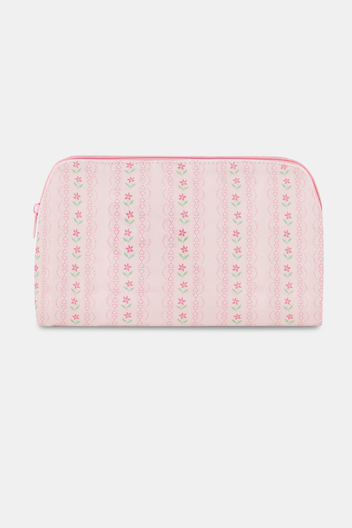 The Daisy Heart Stripe Makeup Bag by Roller Rabbit is a pink cotton canvas cosmetic pouch with a zipper, adorned with a delicate pattern of pink lines and small green and pink floral motifs on a light background.
