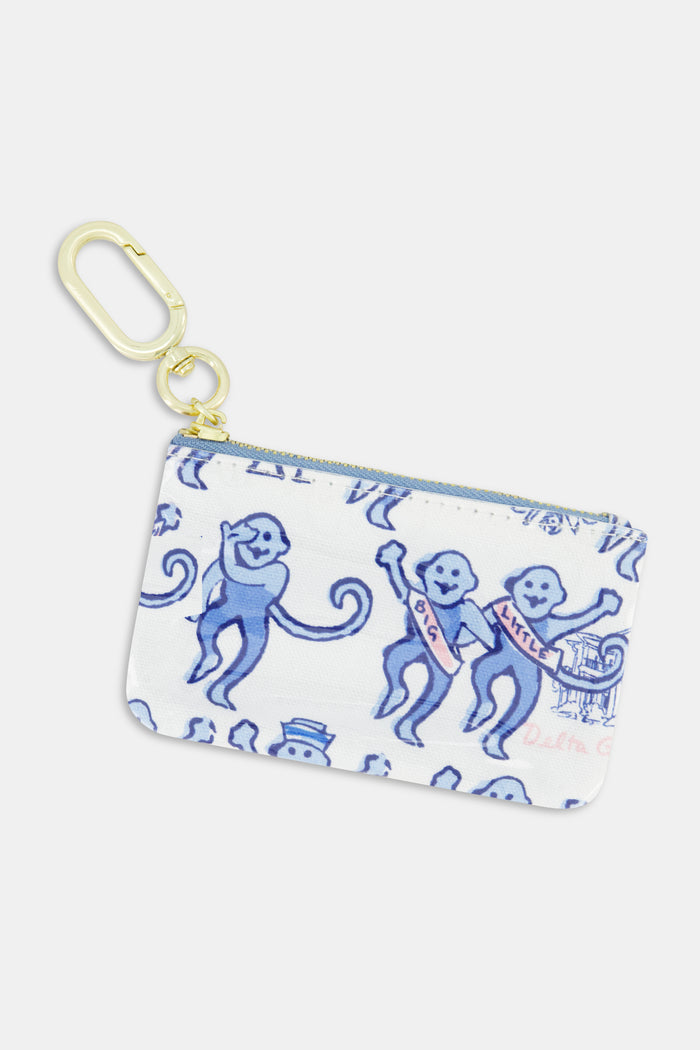 The Delta Gamma Monkey Coin Pouch by Roller Rabbit is a small zippered pouch featuring blue cartoon monkeys with sashes labeled “GG” and “Kitten,” set against a white background with whimsical designs and finished with a gold key clip. It’s the perfect sorority accessory or fun gift for Delta Gamma members.