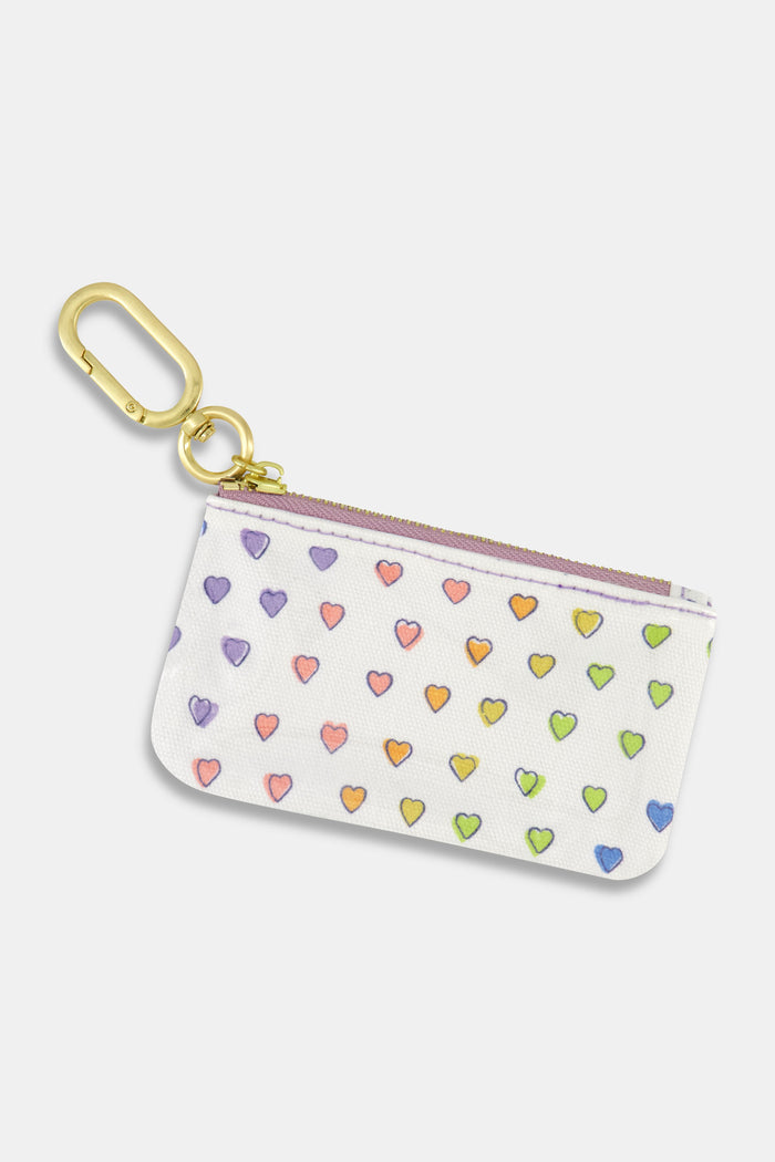 Keep essentials secure with the Roller Rabbit Disco Hearts Coin Pouch—a small white cotton canvas pouch featuring a gold clip and a colorful, hand-drawn heart pattern. Water-resistant for everyday use.