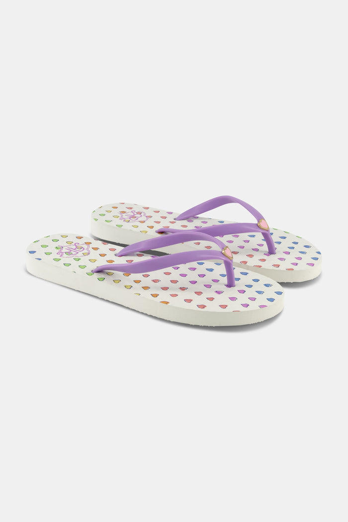 Roller Rabbit's Disco Hearts Flip Flops feature a colorful heart pattern and light purple straps, making them the perfect vacation footwear. Shown here against a plain white background.