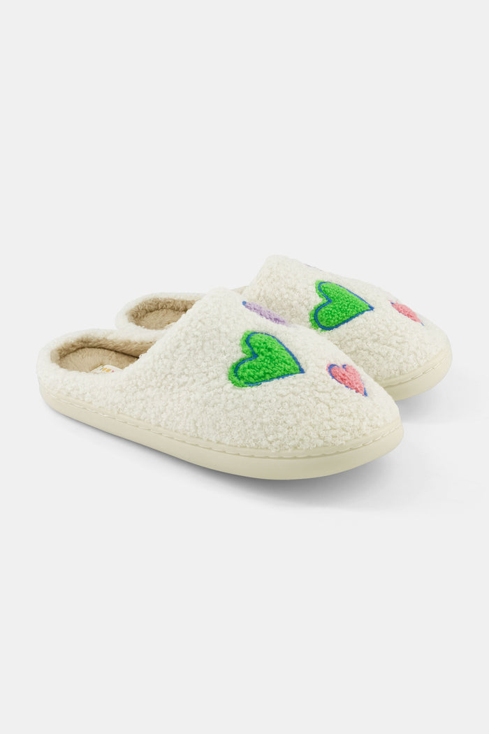 The Roller Rabbit Disco Hearts Fuzzy Slippers are white shearling slippers featuring green and pink heart designs, shown on a plain white background.