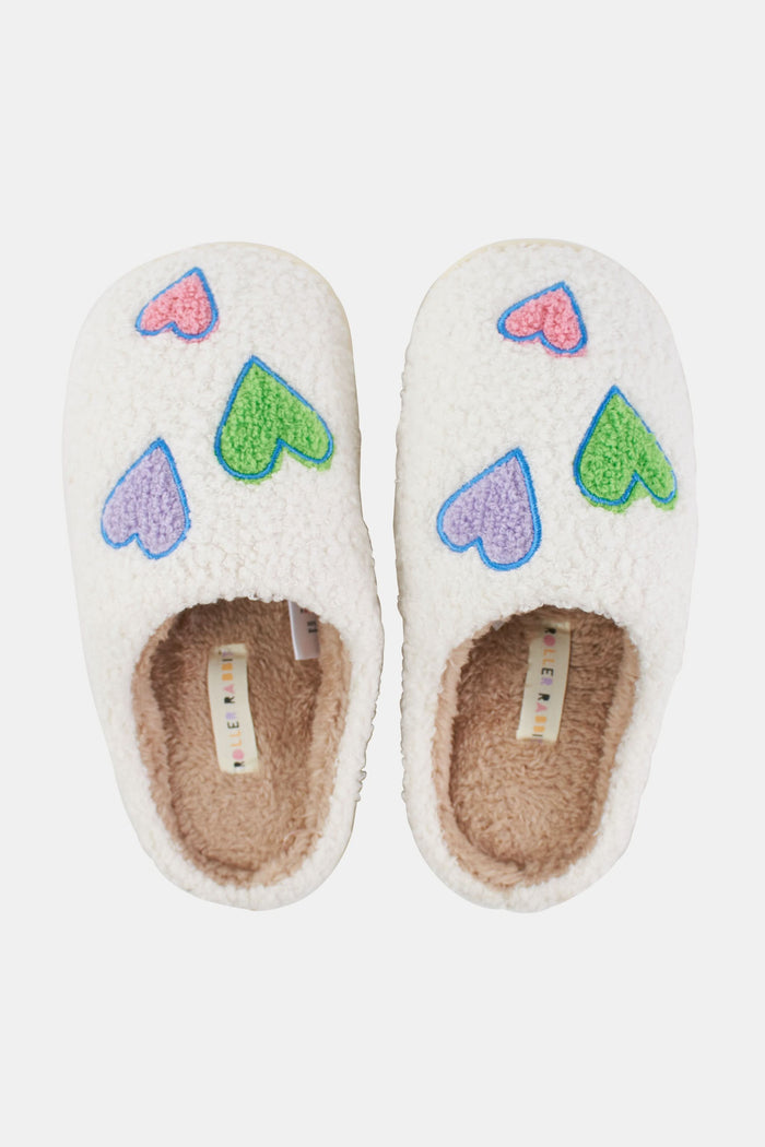 The Roller Rabbit Disco Hearts Fuzzy Slippers are white shearling slippers featuring green and pink heart designs, shown on a plain white background.