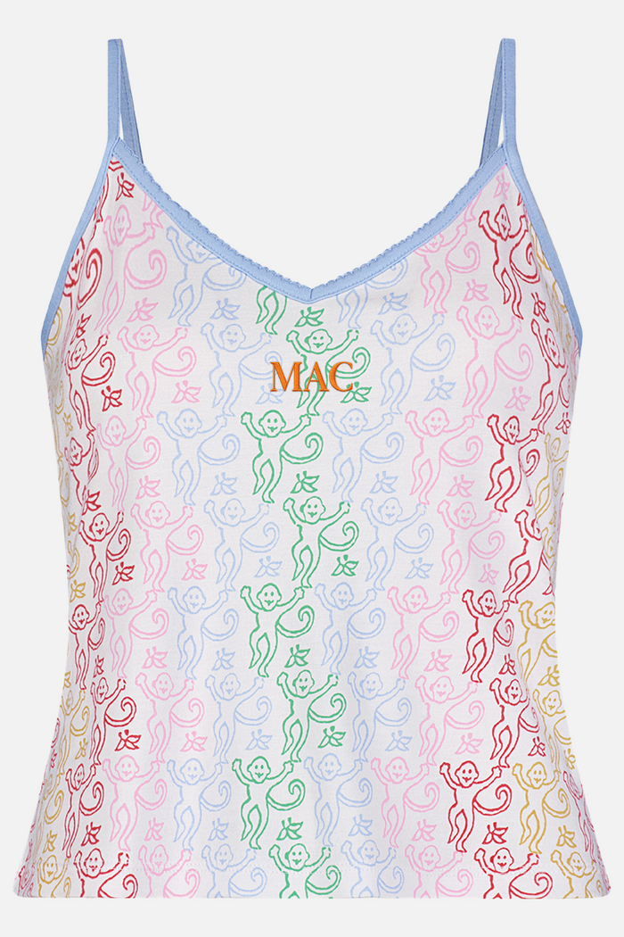 A woman stands barefoot wearing the Roller Rabbit Disco Monkey Lily Set, a matching Pima cotton pajama set featuring a pastel lace-like pattern, sleeveless camisole top, and drawstring pants with pockets.