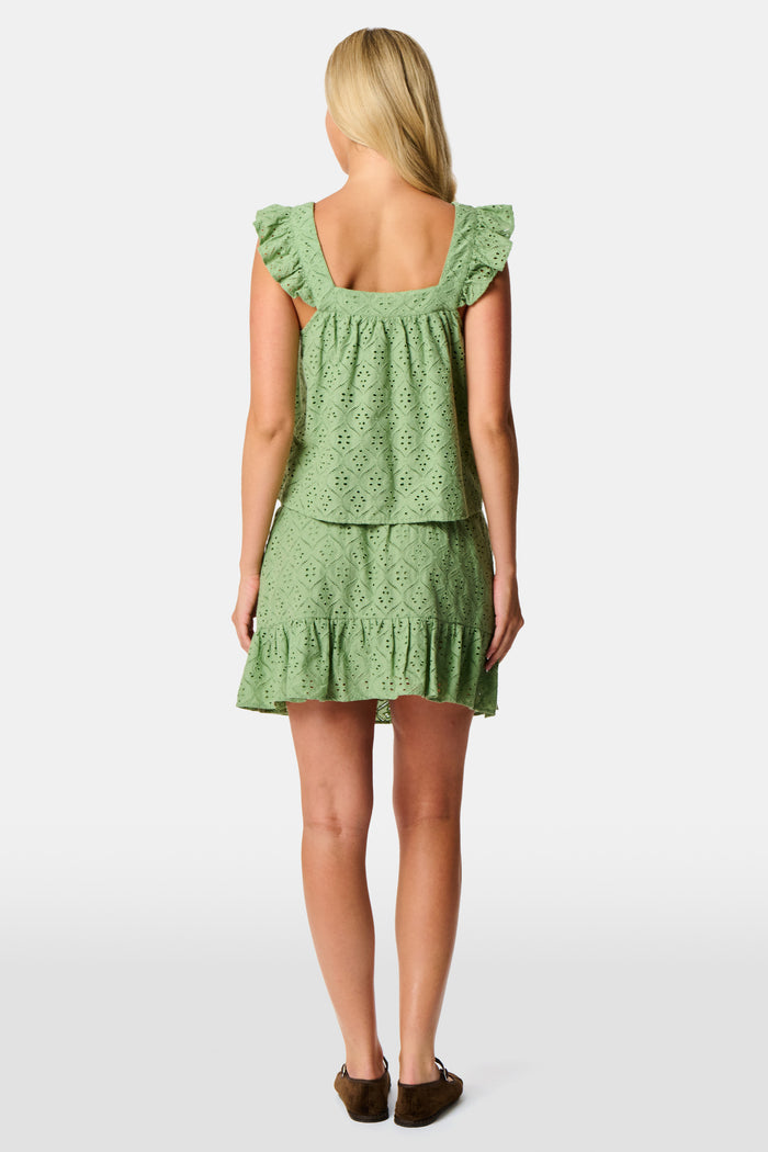 A woman wearing the Roller Rabbit Elsa Eyelet Nicole Top in sage green cotton, featuring an eyelet pattern and ruffled shoulder straps, shown from the shoulders to the waist against a plain background.