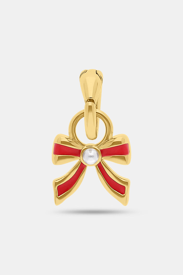 The Enamel Bow Charm by MADISON 501 features a 14K Gold Covered Brass bow with red enamel accents and a white gemstone center—an elegant holiday accessory, shown on a plain white background.