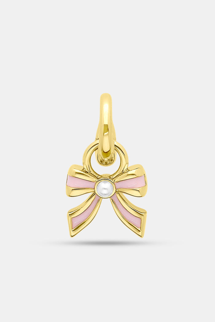 The Roller Rabbit Enamel Bow Charm features 14K gold-covered brass with light pink enamel accents and a small white central gem, photographed against a plain light background.