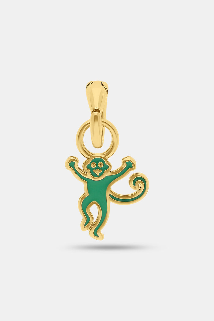 The Enamel Monkey Charm by MADISON 501 features a smiling face and curly tail in green enamel on 14K gold covered brass, making playful holiday jewelry. Shown on a plain white background.