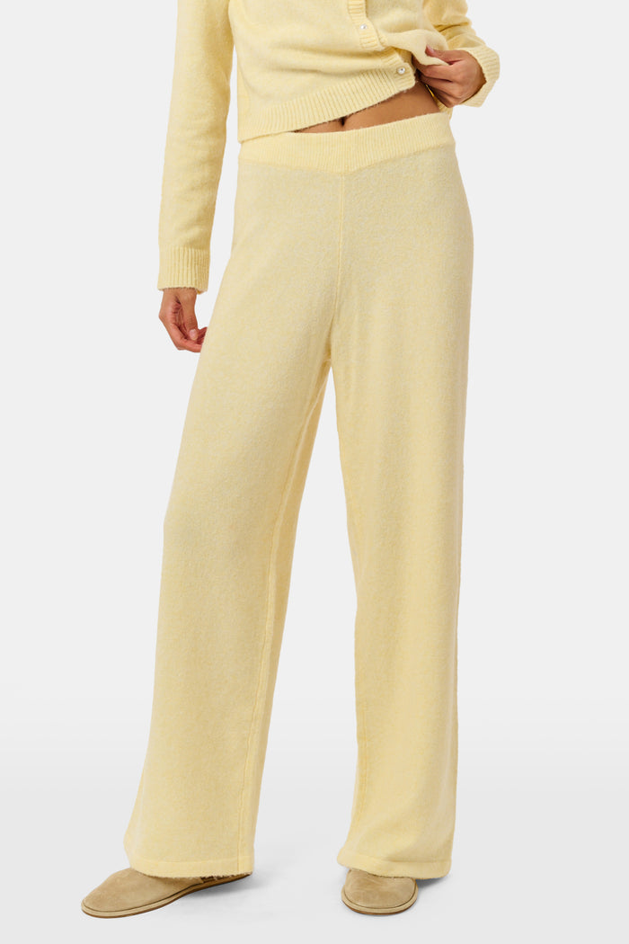 A person wearing the Roller Rabbit Gaia Pant paired with a light yellow knit sweater and beige slippers stands against a plain white background.