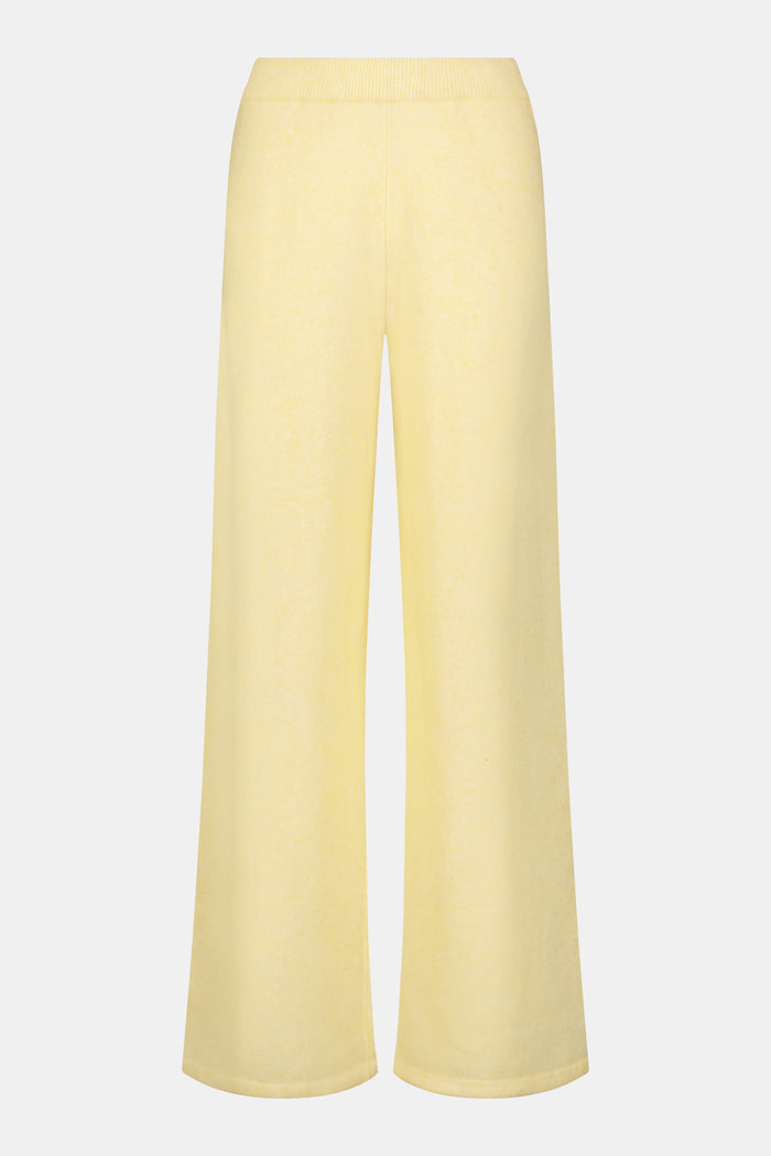A person wearing the Roller Rabbit Gaia Pant paired with a light yellow knit sweater and beige slippers stands against a plain white background.