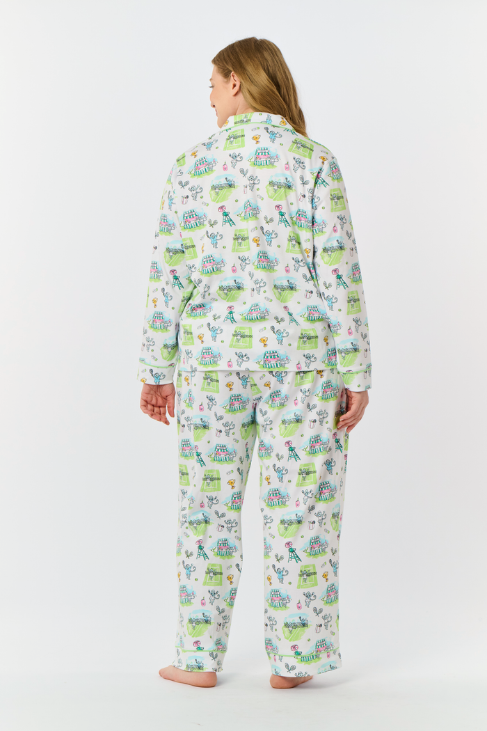 Introducing the Game, Set, Monkey Long Sleeve Polo Pajamas by Roller Rabbit—a cozy white pajama set expertly crafted from soft Pima Cotton. The set features a playful Game Set Monkey print with vibrant green, blue, and yellow animal and nature illustrations. Designed with long sleeves, a button-up polo top, and comfortable drawstring waist pants, this delightful set is showcased against a plain light background.