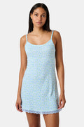 The Roller Rabbit Garden Gate Floral Daniela Slip Dress features a sleeveless, knee-length silhouette with thin straps, a blue and green floral Garden Gate print, and blue lace trim at the hem, shown against a plain white background.