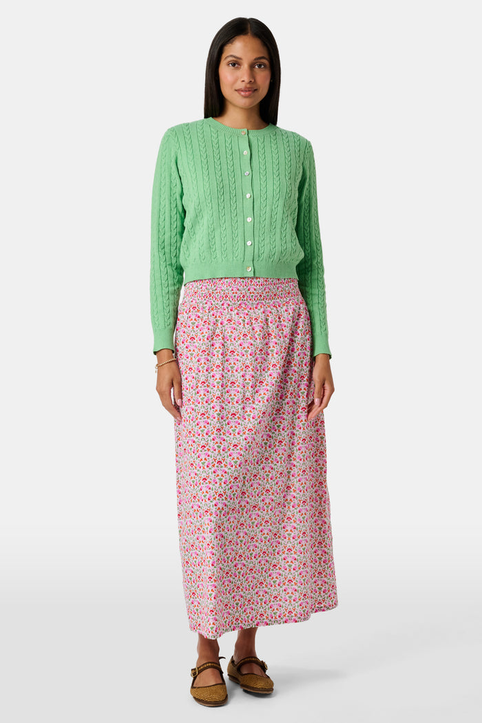 A Roller Rabbit Kids Garden Gate Floral Alexis Skirt with matching briefs, both showcasing a pink, green, and white flower pattern, is displayed on a plain white background. This cotton skirt is ideal for girls who love playful floral prints.