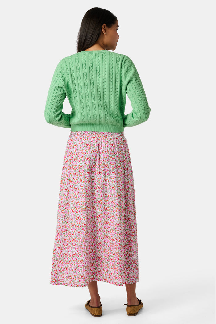 A Roller Rabbit Kids Garden Gate Floral Alexis Skirt with matching briefs, both showcasing a pink, green, and white flower pattern, is displayed on a plain white background. This cotton skirt is ideal for girls who love playful floral prints.