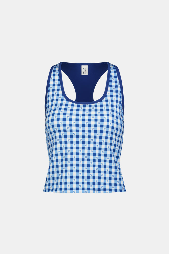A person wears the Roller Rabbit Gingham Hearts Bella Tank, a blue-and-white checkered racerback style with small heart details. The image is cropped at the shoulders and midsection, showing part of the matching skirt and the person’s head.