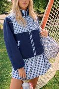 A woman wearing the Roller Rabbit Gingham Hearts Marina Fleece Jacket stands by a sports net outdoors, holding a patterned tote and a water bottle.