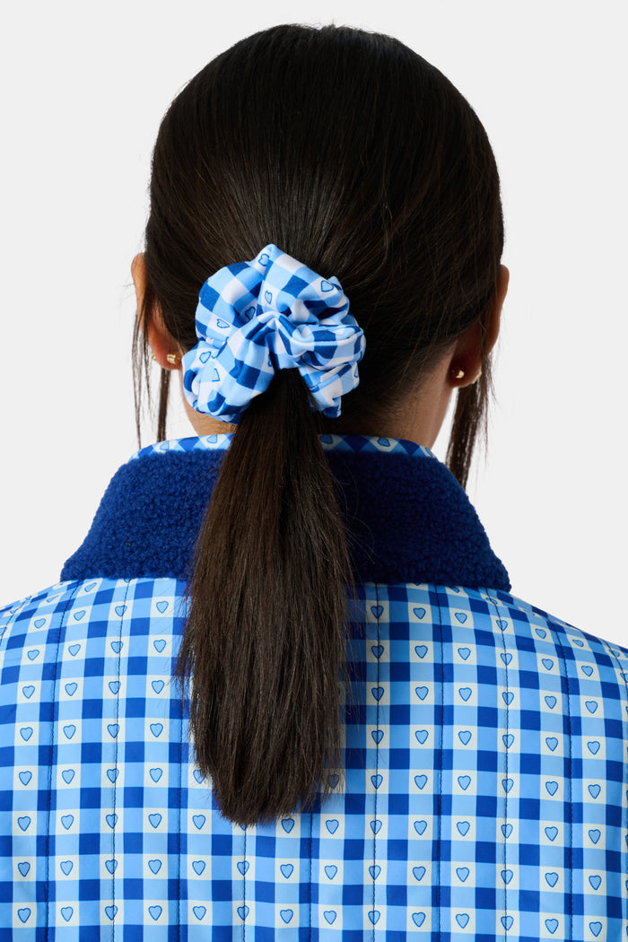 The Roller Rabbit Gingham Hearts Scrunchie Set Of 2 features one pink and white gingham scrunchie with small hearts and one blue and white gingham scrunchie with small hearts, displayed vertically on a plain background.