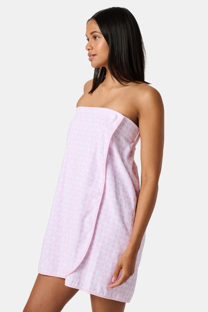 The Roller Rabbit Gingham Hearts Spa Headband is crafted from 100 cotton terrycloth and showcases a pink and white checkered pattern accented with small hearts. It features a convenient hook-and-loop fastener and is displayed laid flat on a white background.