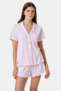 The Gingham Hearts Wyatt Polo Pajamas by Roller Rabbit are a pink and white gingham short-sleeve pajama set, featuring a button-up shirt with chest pocket and matching shorts with a ruffled hem, all crafted from soft Pima cotton. This set is shown on a white background.