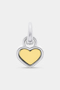 The Roller Rabbit Heart Charm is a heart-shaped pendant with a yellow gold center and a silver border, designed with a top loop for easy attachment to your favorite bracelet or necklace. It is displayed against a plain light gray background.