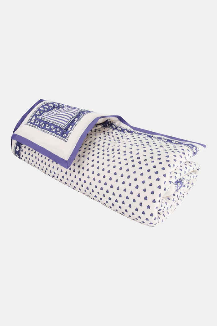 The Hearts Baby Quilt by Roller Rabbit is a folded white cotton quilt with blue and purple geometric borders, adorned with small heart prints—perfect for baby bedding.