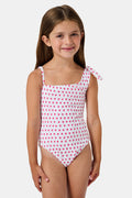 The Roller Rabbit Hearts Kids Jacey One Piece is a swimsuit with an asymmetrical neckline, white fabric dotted with pink hearts, and an adjustable knot-tied shoulder strap.
