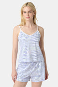 A woman wears the Roller Rabbit Hearts Mischa Set, a Pima cotton loungewear set with a white base and blue hearts. The set includes a sleeveless camisole top and shorts, styled against a plain light background.