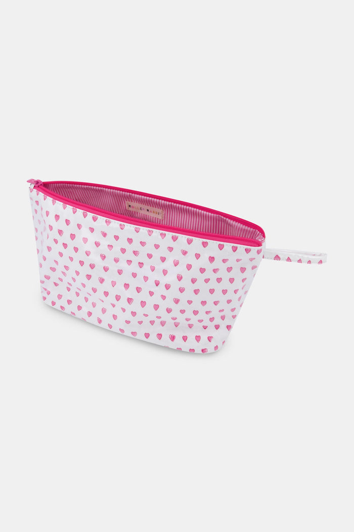 The Hearts Toiletry Case by Roller Rabbit is a white, water-resistant zip pouch with a pink zipper and handle, adorned with small pink hearts—perfect for organizing your travel essentials.