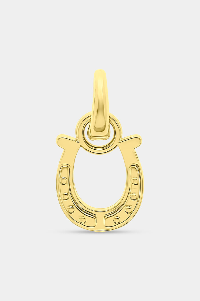 The Roller Rabbit Horseshoe Charm is a gold, horseshoe-shaped pendant designed as a luck charm, featuring a small loop at the top for attaching to a chain and set against a plain white background.