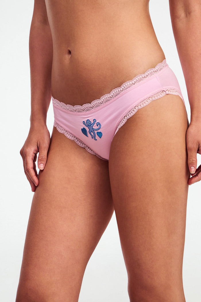 Roller Rabbit Icons Bikini 4 Pack features four girls' panties: solid pink with butterfly, white with colorful dots and blue trim, pink with hearts, and green geometric modal with lace trim.