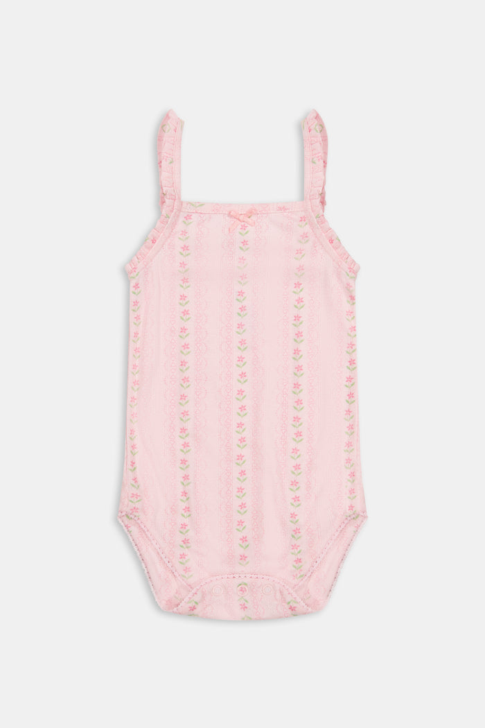 The Roller Rabbit Infant Daisy Heart Stripe Ava Onesie is a pink Pima cotton baby romper with thin shoulder straps, delicate ruffle details, and a subtle floral pattern. This sleeveless design features a small bow at the neckline and is shown against a plain white background.