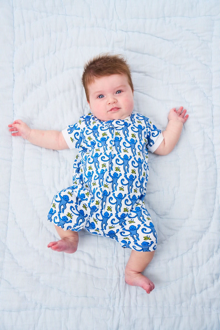 The Roller Rabbit Infant Monkey Short Sleeve Zipper Onesie is made from soft white Pima cotton, features a blue monkey and yellow star print, short sleeves, and a convenient front zipper for easy changes.