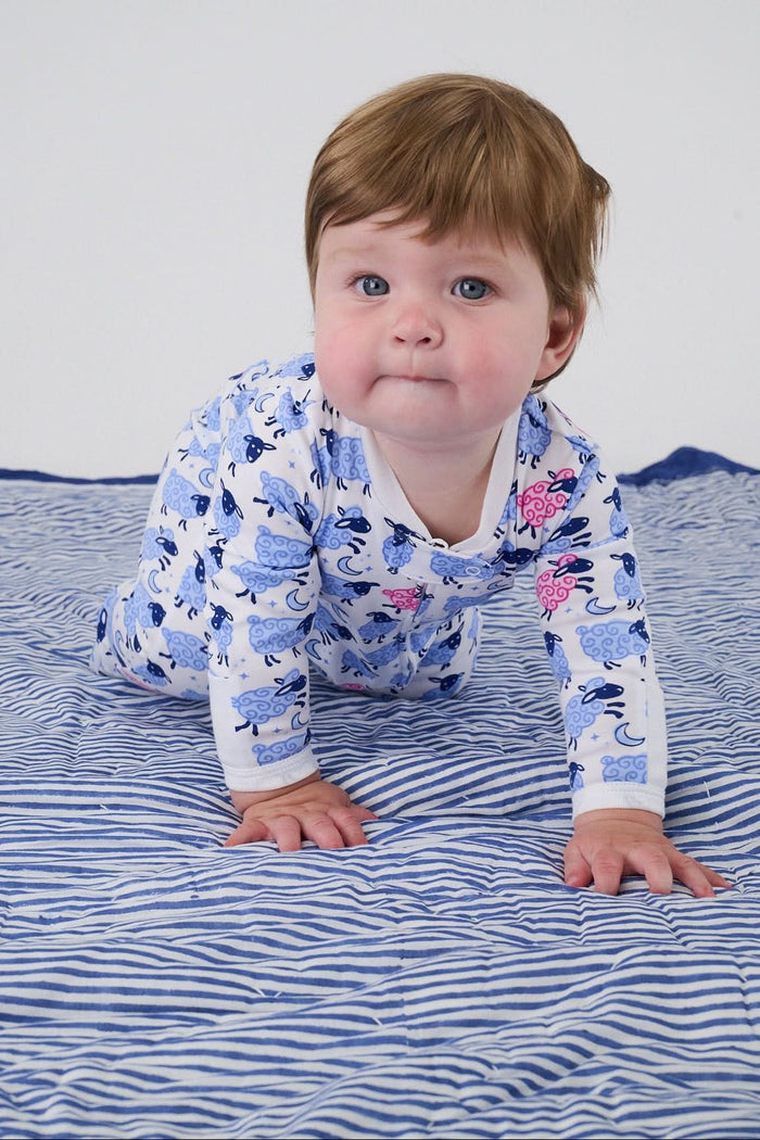 The Roller Rabbit Infant Sammy The Sheep Zipper Footie, shown on a plain light background, features a blue and white pattern with playful blue and pink sea creatures, long sleeves, two-way front zipper, and fold-over mitten cuffs.
