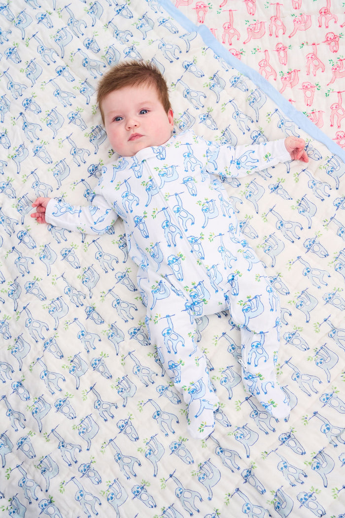 The Roller Rabbit Infant Sleepy Sloth Zipper Footie is a white long-sleeve onesie with blue sloths on green branches, made from 100 Pima cotton and featuring a convenient zipper for easy changing.