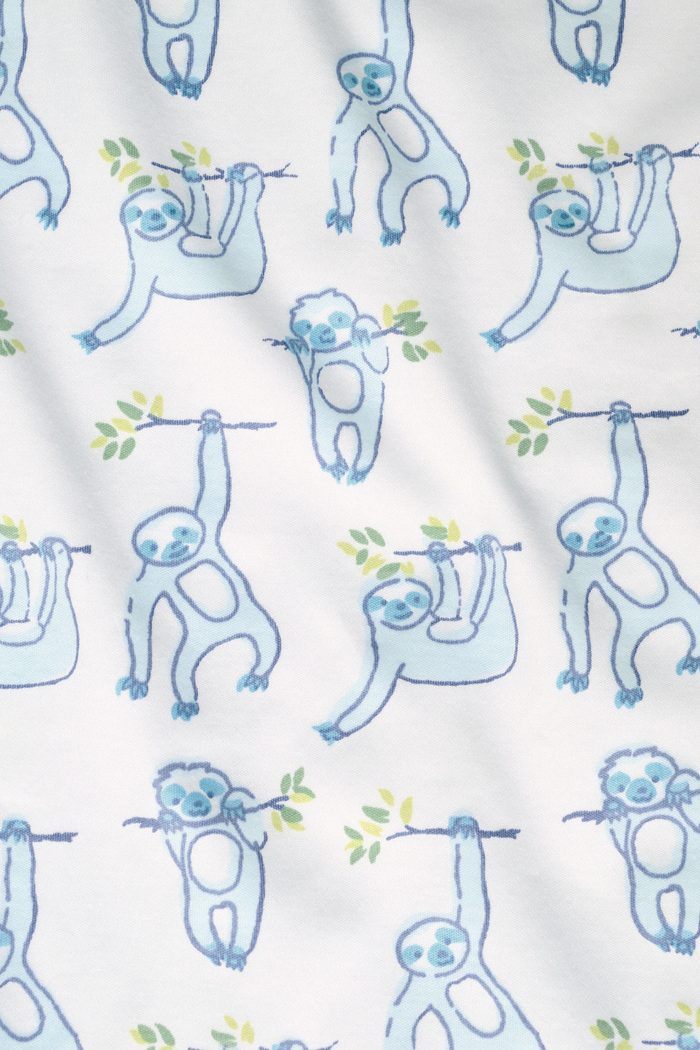 The Roller Rabbit Infant Sleepy Sloth Zipper Footie is a white long-sleeve onesie with blue sloths on green branches, made from 100 Pima cotton and featuring a convenient zipper for easy changing.
