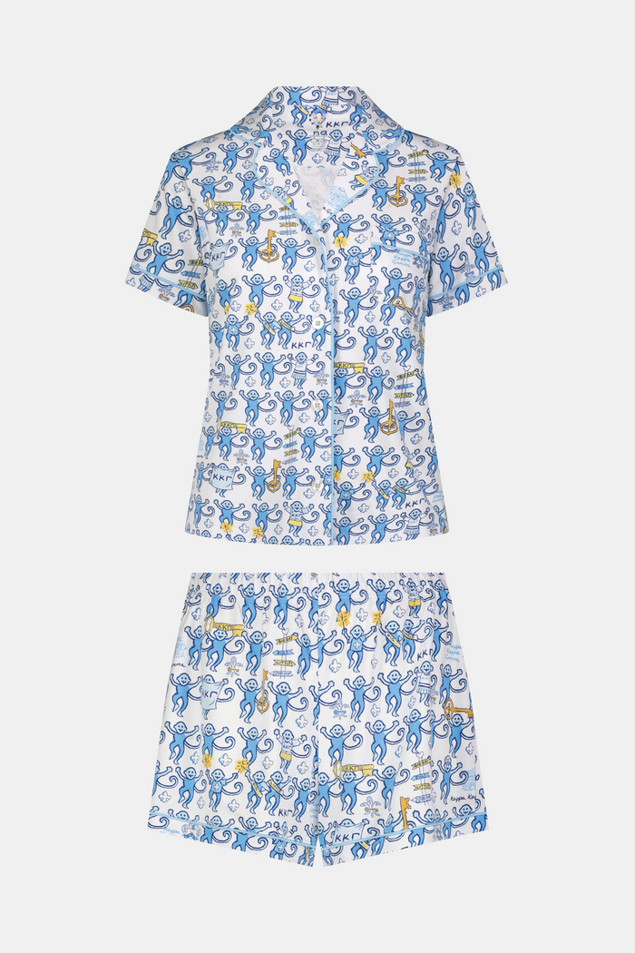 The Roller Rabbit Kappa Kappa Gamma Monkey Polo Pajamas feature a short-sleeve button-up pajama shirt with a front button placket and matching shorts with an elastic waistband, adorned with a playful blue monkey and yellow motif on a white background. Crafted from soft Pima cotton for extra comfort.